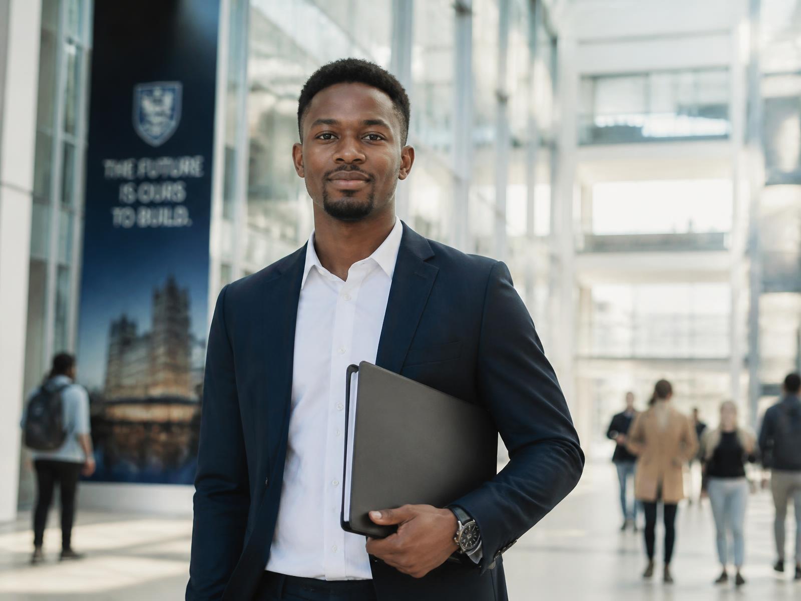 Confident young Black African professional holding a folder in a modern international university building